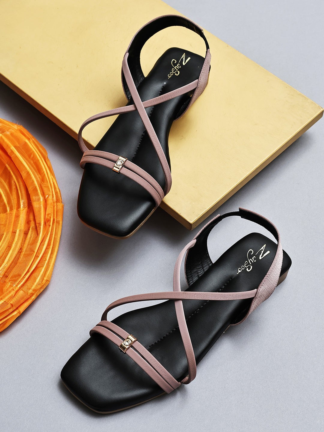 Zaysoo women's black flat sandals with pink criss-cross straps and a gold buckle detail.