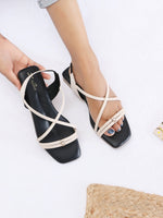 Zaysoo cream criss-cross strap flat sandals with a square toe and subtle metallic ornament. Features a back strap for secure fit.