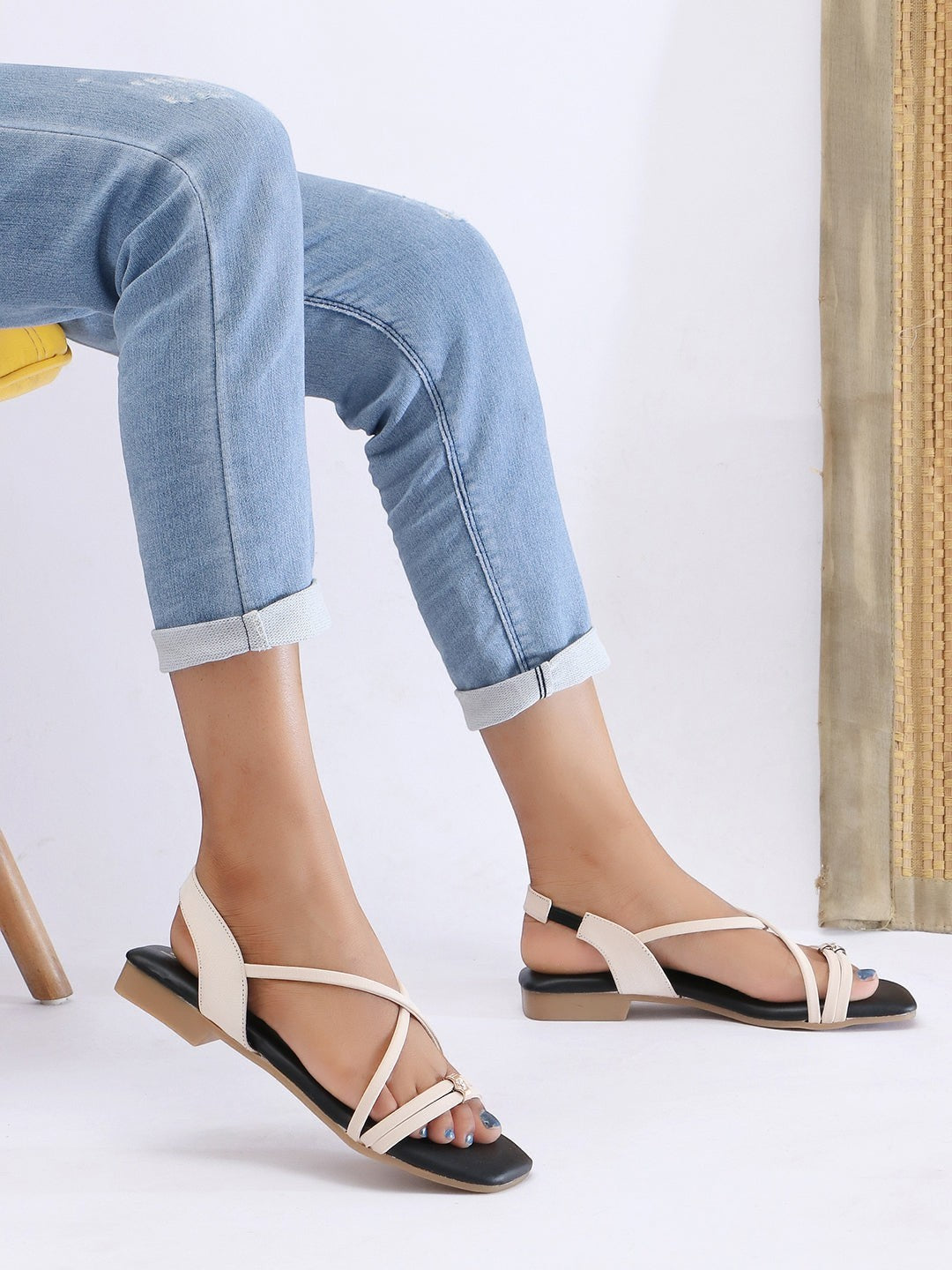 Zaysoo women's cream and black criss-cross strap flat sandals with back strap and metallic detail.